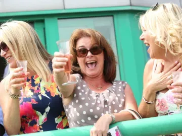 A hospitality guest at Brighton Races toasting a glass of bubbly