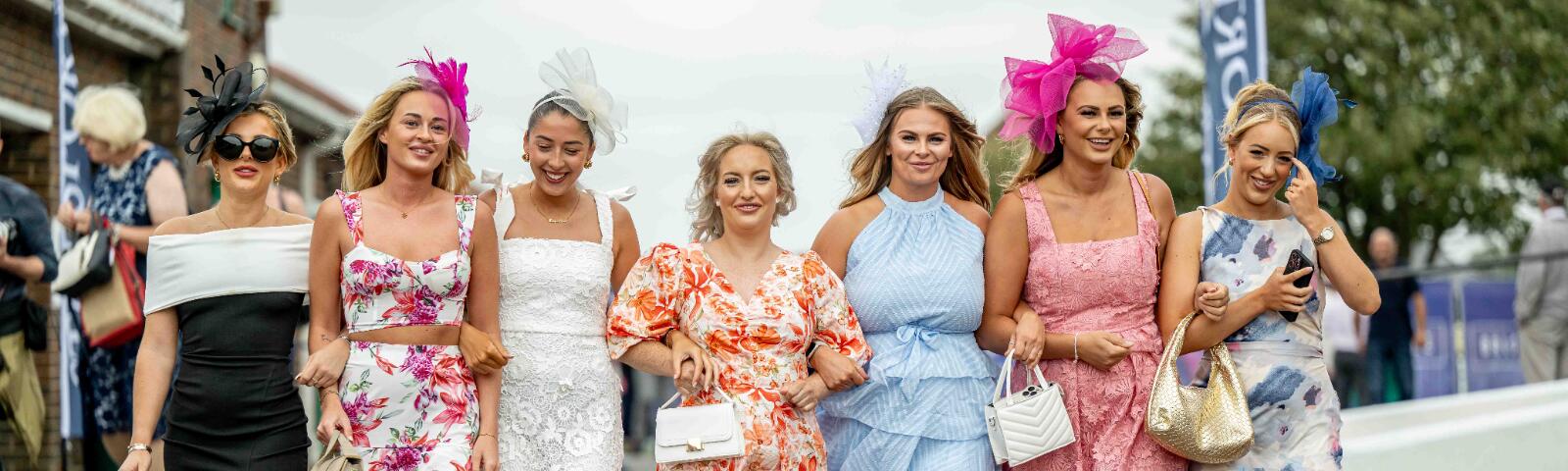 A group of beautifully dressed ladies heading into Brighton Races
