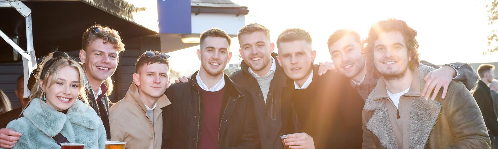 A large group of friends enjoy the races at Brighton