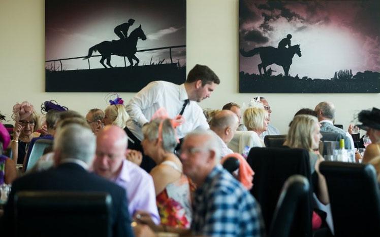 A waiter serving guest in a Brighton Racecourse restaurant