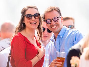 A man and woman enjoy a day at the races